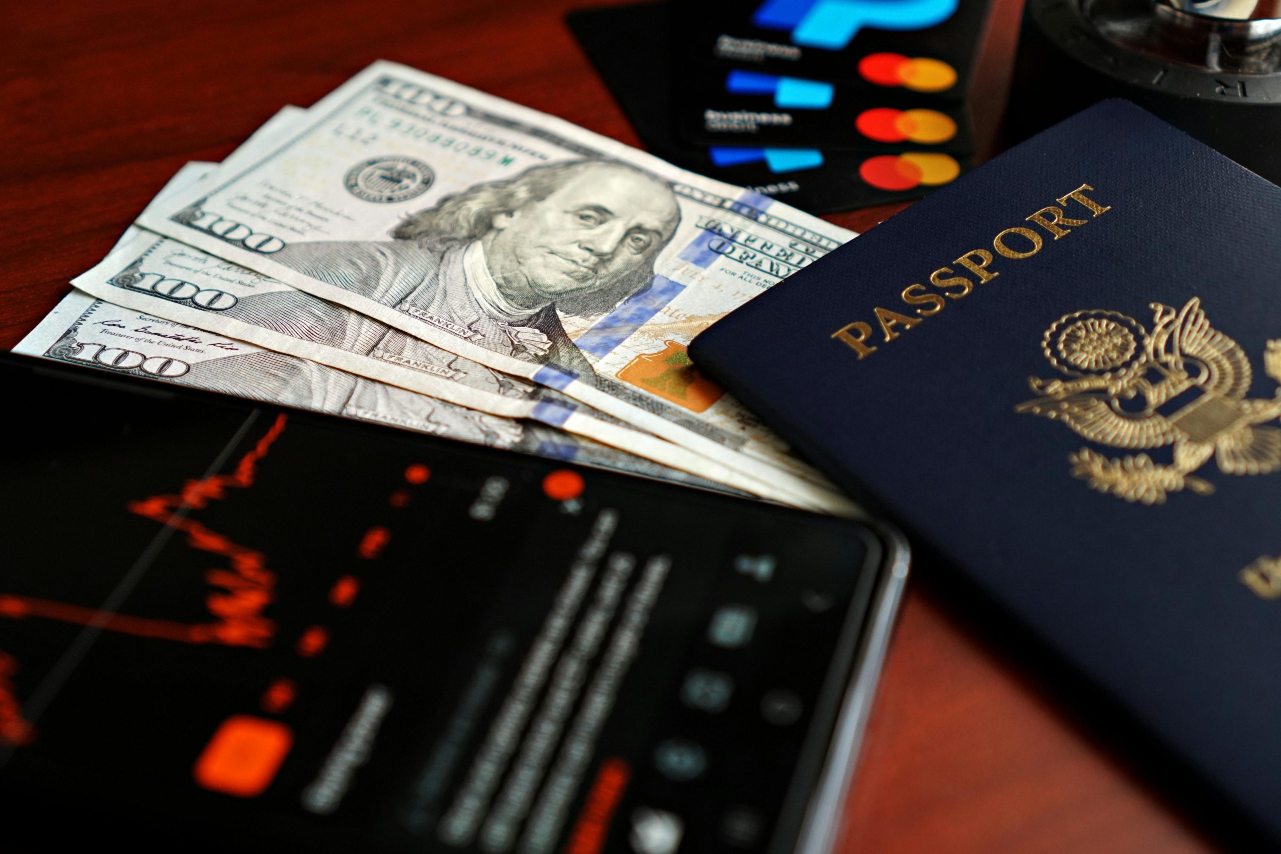 Image of financial elements including US dollars, passport, and digital representation of stock market trends.
